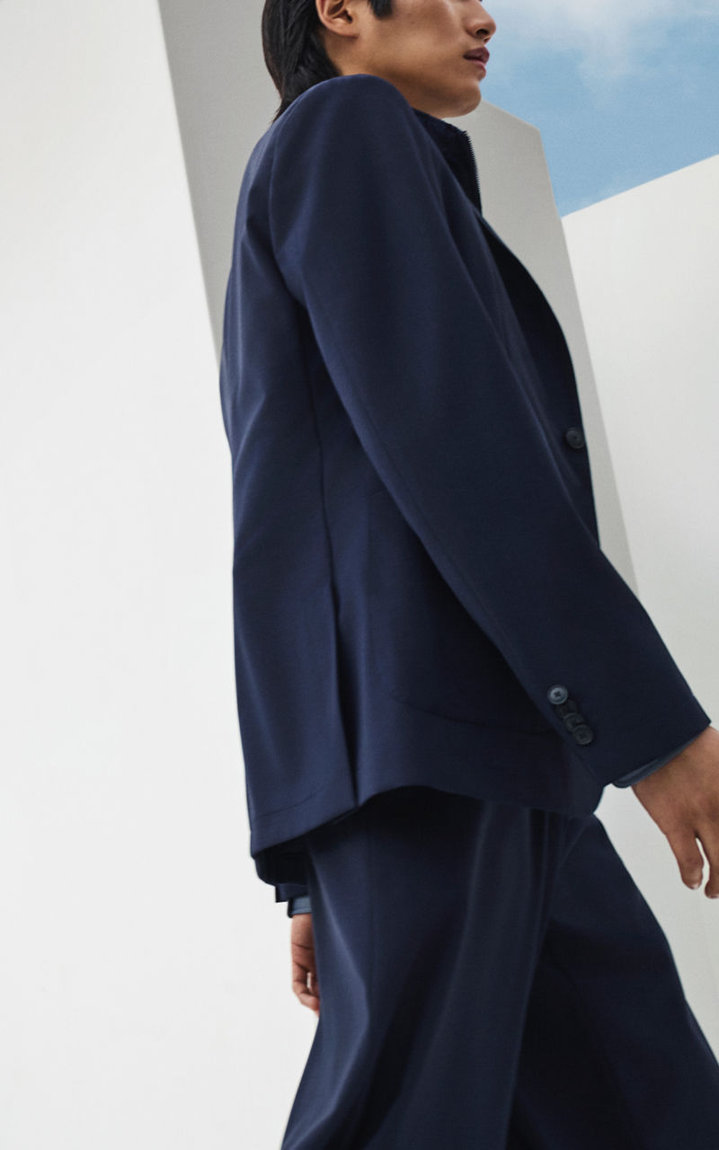 male model wearing the new BOSS Performance suit in navy blue