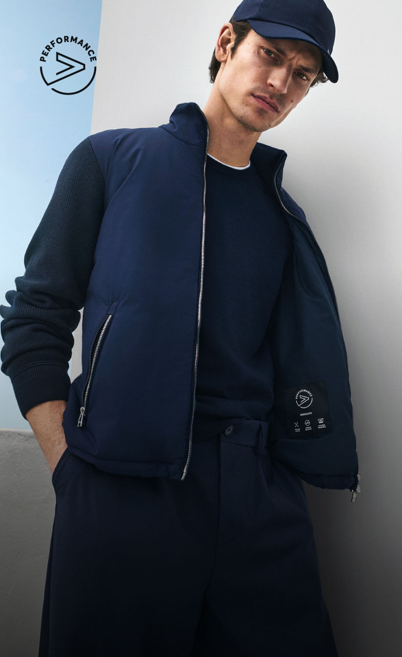 mannequin homme portant une tenue bleu marine BOSS Performance composée d’une pièce en maille, d’une veste légère et d’une casquette de base-ball