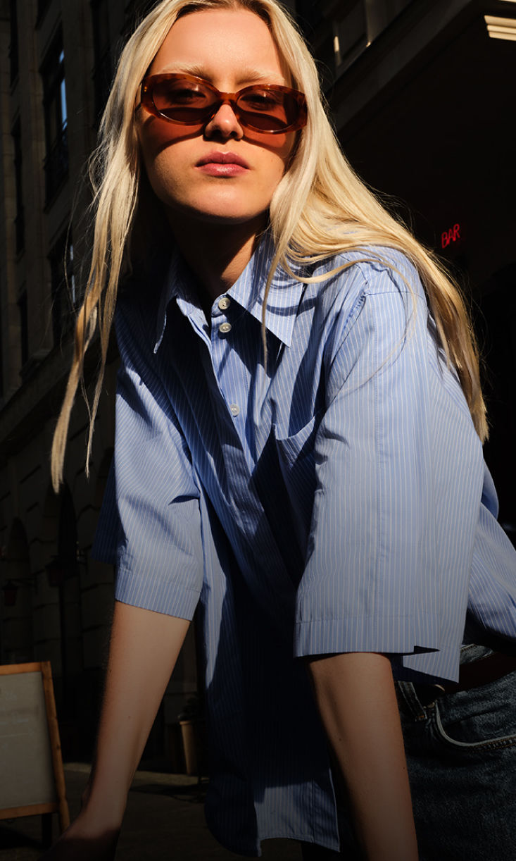 Women is wearing blue blouse by BOSS