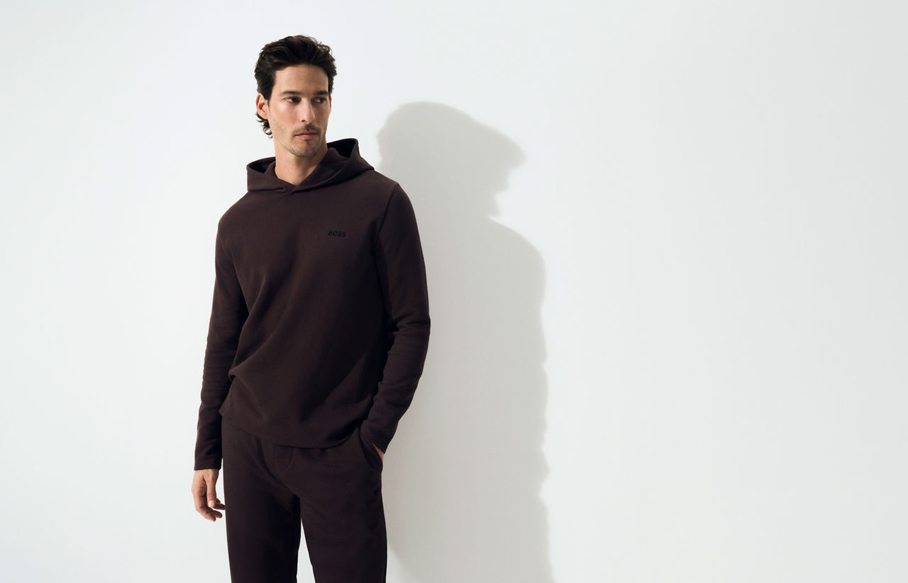Model wearing lounge wear, grey short jersey trousers and black jersey zip jacket  