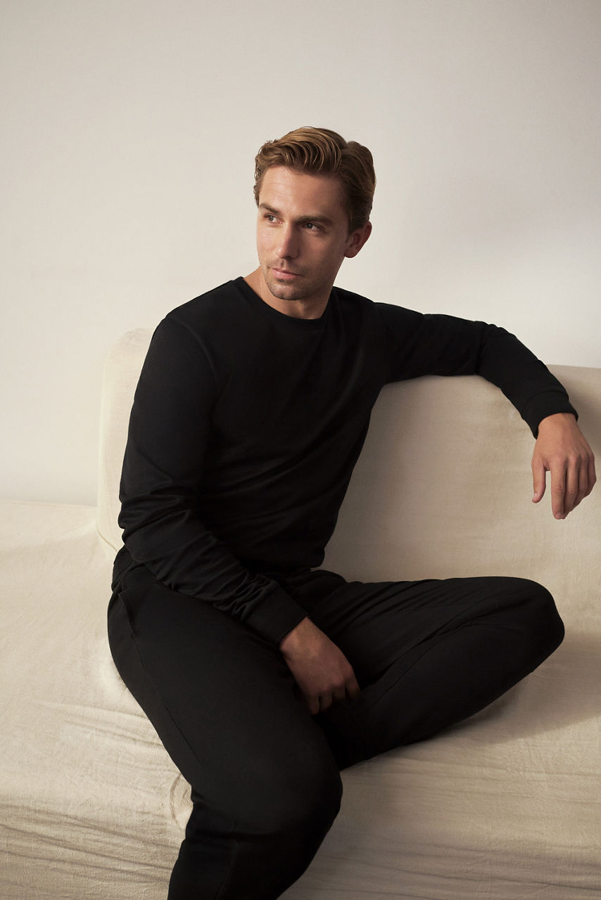 Model wearing lounge wear, grey short jersey trousers and black jersey zip jacket  