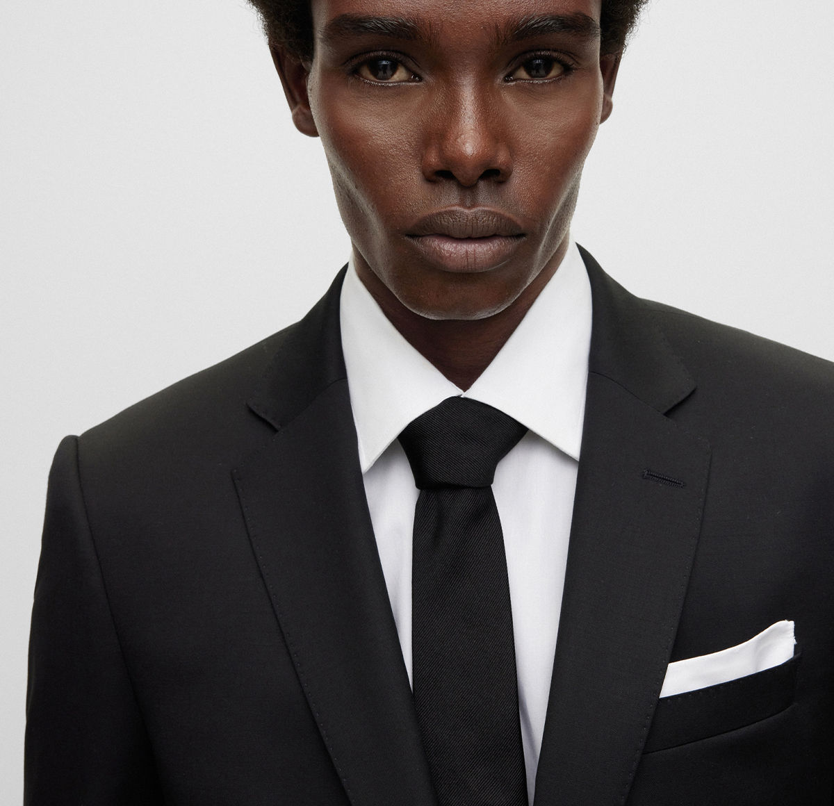 Costume noir BOSS avec une pochette de costume blanche
