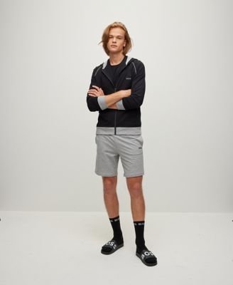 Model wearing lounge wear, grey short jersey trousers and black jersey zip jacket  