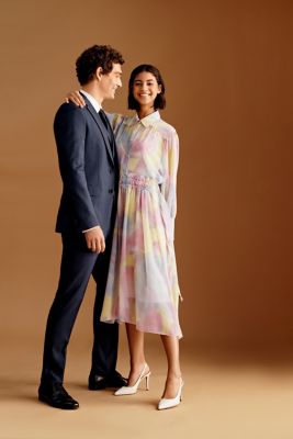 Male model wearing blue suit for BOSS Men, while female model wearing colourful dress for BOSS Women