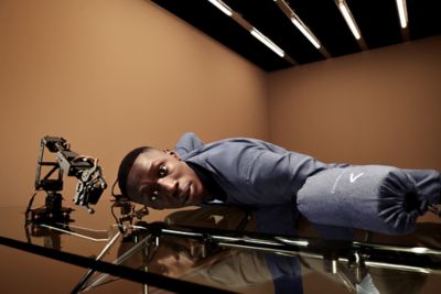 Khaby wearing a blue packable suit and presenting the matching bag 