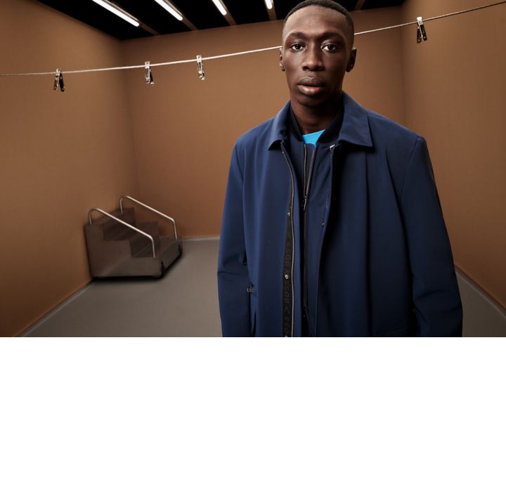 Khaby wearing a packable blue suit with a packable blue coat on top 