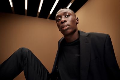 Khaby wearing the new BOSS one suit in black with black t-shirt underneath 