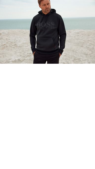 Alex Thomson draagt een zwarte hoodie met een BOSS-logo