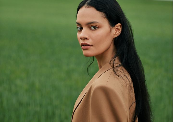 vrouw draagt een camel pak van BOSS dat op verantwoorde wijze is geproduceerd