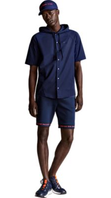 dark blue jesery shorts with a dark blue t-shirt with a big print on the chest and a short sleeved hooded sweatshirt jacket overneath and a dark blue cap for men by BOSS