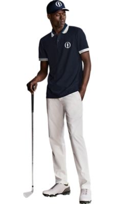 white trouser with a dark blue poloshirt with white details and a dark blue hat for men by BOSS