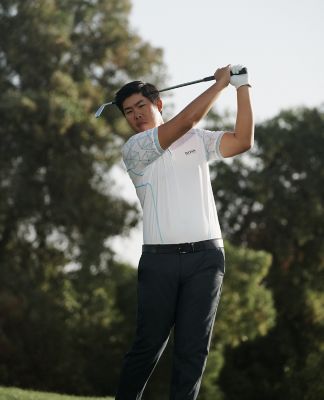 Byeong-Hun An wearing a polo shirt and golf trousers by BOSS